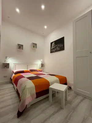 a bedroom with a large bed and a table at Appartamento San Lorenzo di Massimo & Luisa in Rome