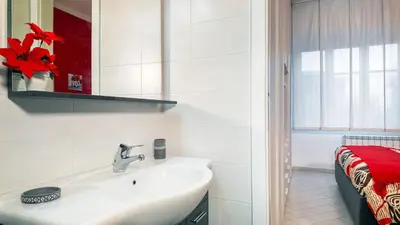 a white bathroom with a sink and a window at Il Sogno Romano in Rome