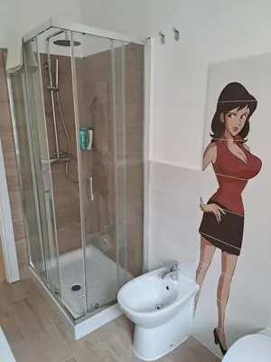 a bathroom with a painting of a woman next to a shower at 102 DreamHouse metropolitana B Libia in Rome