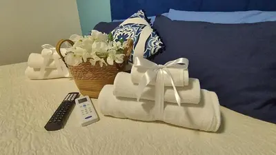 a basket of towels and a remote control on a bed at 102 DreamHouse metropolitana B Libia in Rome