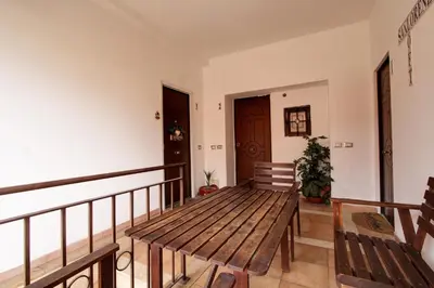 a wooden table on a balcony with two benches at San Lorenzo Elegante loft in Rome