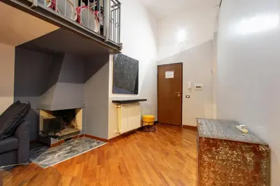 a living room with a staircase and a fireplace at San Lorenzo Elegante loft in Rome