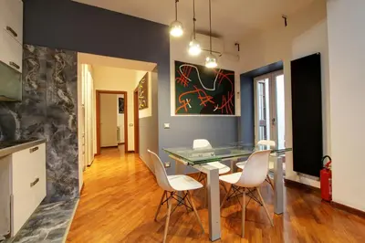 a dining room with a glass table and white chairs at San Lorenzo Elegante loft in Rome