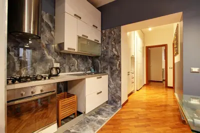 a kitchen with white cabinets and a stove at San Lorenzo Elegante loft in Rome