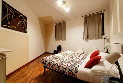 a bedroom with a bed with red pillows on it at San Lorenzo Elegante loft in Rome