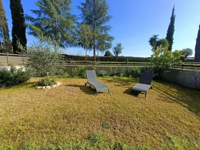 two chairs sitting on the grass in a yard at Roberta and Luca cozy apartment with garden, terrace and pool in Rome