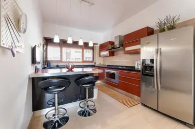 a kitchen with a stainless steel refrigerator and two bar stools at Cielo Suite, Panoramic Apt View with Jacuzzi in Rome