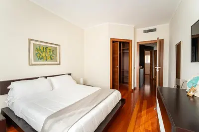 a bedroom with a large white bed and a table at Cielo Suite, Panoramic Apt View with Jacuzzi in Rome