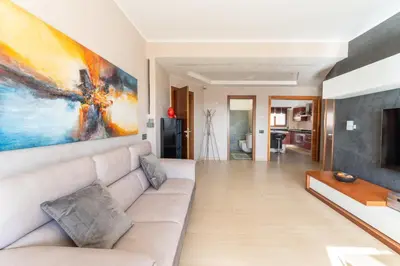 a living room with a couch and a painting on the wall at Cielo Suite, Panoramic Apt View with Jacuzzi in Rome