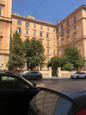 a car parked in front of a large building at Appartement familial au coeur de Rome in Rome