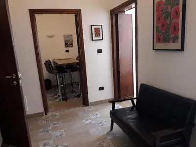 a room with a door and a chair and a table at Appartement familial au coeur de Rome in Rome