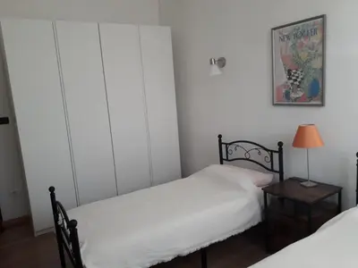 a bedroom with two beds and a lamp on a table at Appartement familial au coeur de Rome in Rome