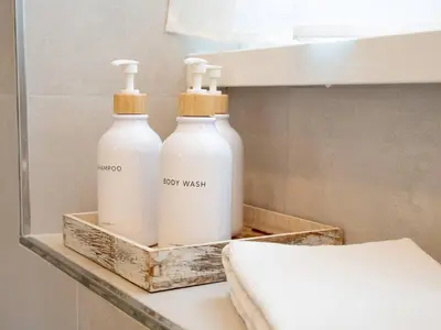 two bottles of body wash sitting on a shelf in a bathroom at Flaminia Garden Suite in Rome