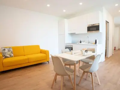 a living room with a yellow couch and a table and chairs at Flaminia Garden Suite in Rome