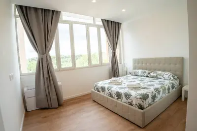 a bedroom with a bed in a room with windows at Flaminia Garden Suite in Rome