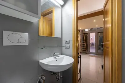 a bathroom with a white sink and a hallway at Monti House - City Center in Rome