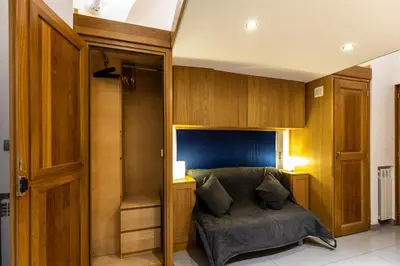 a bedroom with a bed in a room with wooden cabinets at Monti House - City Center in Rome