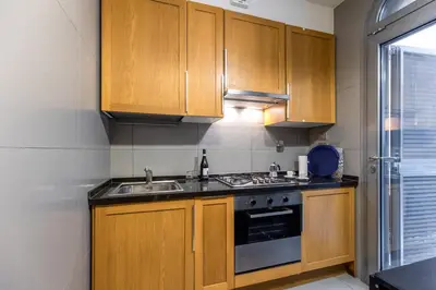 a kitchen with wooden cabinets and a sink at Monti House - City Center in Rome