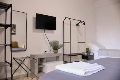 a bedroom with a bed with a tv on the wall at A Casa di Rocco in Rome