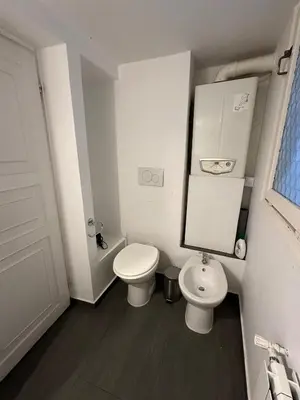 a white bathroom with a toilet and a sink at Piazza NAVONA - CAMPO dei FIORI in Rome