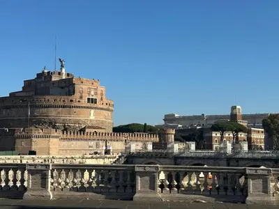 a view of a building with a tower and a bridge at Piazza NAVONA - CAMPO dei FIORI in Rome