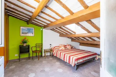 a bedroom with a bed and a table and a chair at Fascinating attic - up to 2 guests - Trastevere in Rome
