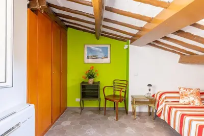 a bedroom with a green wall and a table and chair at Fascinating attic - up to 2 guests - Trastevere in Rome
