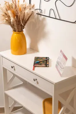 a white desk with a yellow vase on top at Thelma House - lovely apartment near Tiburtina Station in Rome