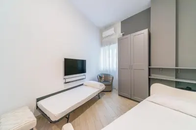 a hospital room with two beds and a flat screen tv at Thelma House - lovely apartment near Tiburtina Station in Rome