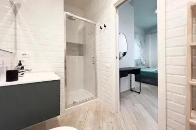 a white bathroom with a shower and a sink at Thelma House - lovely apartment near Tiburtina Station in Rome
