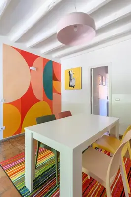 a white table and chairs in a room with a colorful wall at Historic Center - Navona Luxe Haven - Elevator, Soundproof & Netflix in Rome