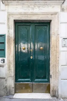 a green door in a building with a stone wall at Historic Center - Navona Luxe Haven - Elevator, Soundproof & Netflix in Rome