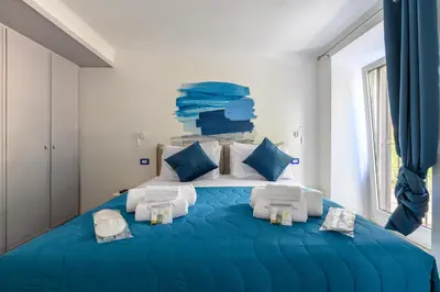 a blue bed in a white room with blue pillows at Historic Center - Navona Luxe Haven - Elevator, Soundproof & Netflix in Rome