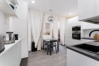 a kitchen with white counters and a black table at MP House in Trastevere in Rome