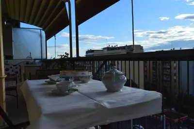 a balcony with chairs and a table with a plate on it at Appia Sweet Home in Rome