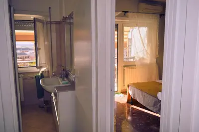 a bathroom with a sink and a bed with a window at Appia Sweet Home in Rome