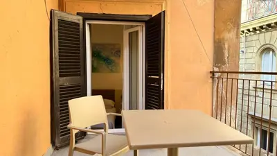 a white chair and a table on a balcony at Chich Suites in the Heart of Historic Rome in Rome