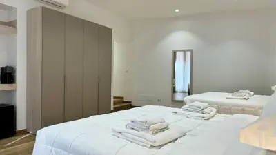 a bedroom with two beds with white towels on them at Chich Suites in the Heart of Historic Rome in Rome