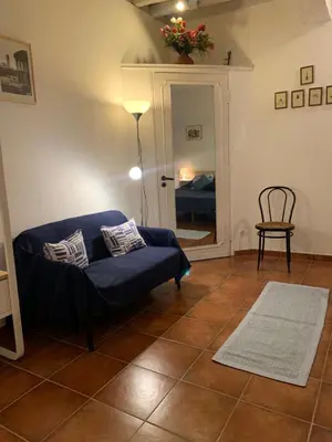 a living room with a blue couch and a chair at Ideal for your Roman Holidays in Rome