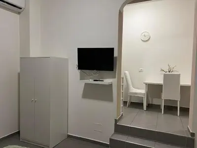 a living room with a table and a tv on a wall at Gemelli tre in Rome
