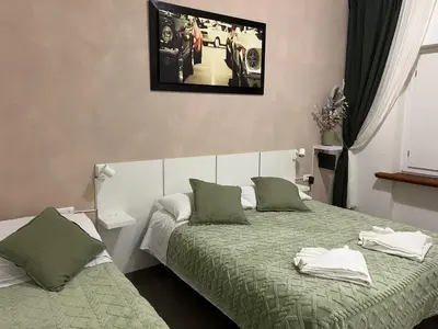 a bedroom with two beds and a picture on the wall at Gemelli tre in Rome