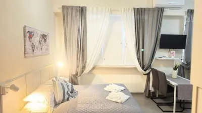 a bedroom with a bed and a desk and a window at Gemelli tre in Rome