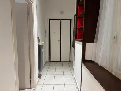 a hallway with a white tile floor and a door at Gianicolense sweet Home in Rome