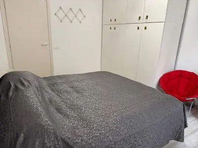 a bedroom with a bed and a red chair at Gianicolense sweet Home in Rome