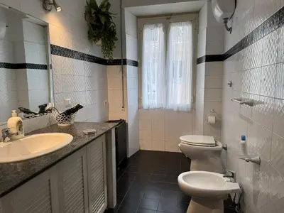 a bathroom with a sink and a toilet and a mirror at Gianicolense sweet Home in Rome