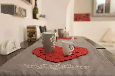 two coffee cups sitting on a red heart napkin at Rome Studio Centro Storico in Rome