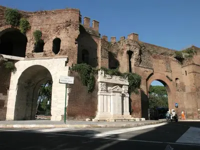 an old brick building with a statue in front of it at Home Relax Appia San Giovanni in Rome