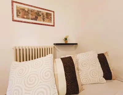 a white couch with two pillows and a radiator at Home Relax Appia San Giovanni in Rome