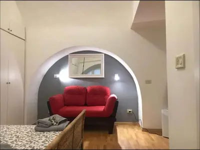 a living room with a red couch in an archway at Cenci Rome Centro Storico in Rome