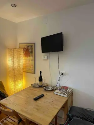 a wooden table with a bottle of wine and a television on a wall at Cenci Rome Centro Storico in Rome